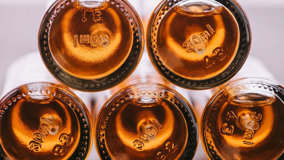 The bottom part of five CBD oil bottles on top of each other