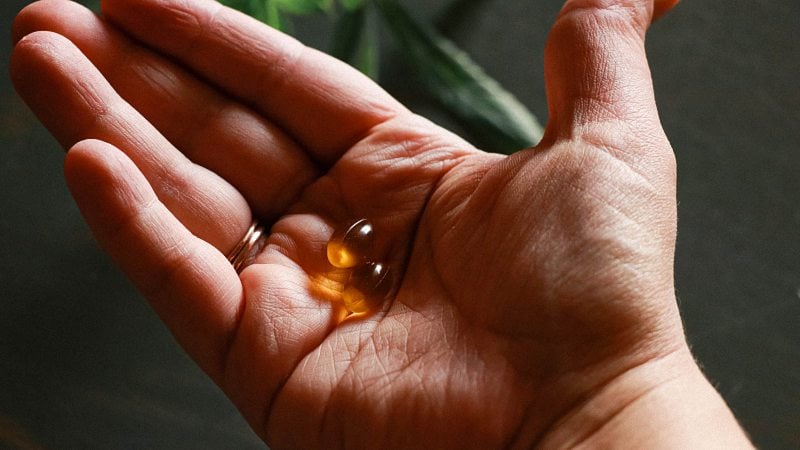 CBD capsules on a person's hand 
