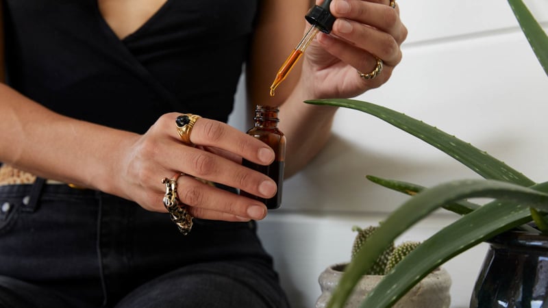 A women holding a CBD oil bottle